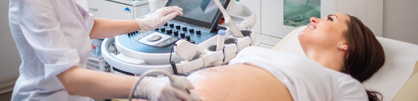 Die Ärztin führt einen Ultraschall bei der schwangeren Patientin durch.