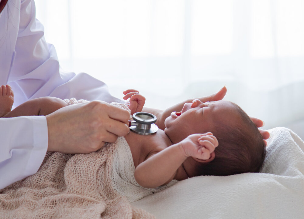 Das Baby wird von einem Arzt untersucht.