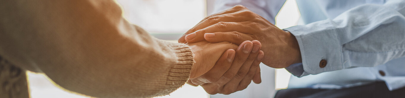 Die Hand des Patienten wird gehalten.